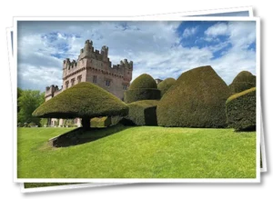 Hutton-in-the-Forest historic house and gardens, with sculpted hedges in the foreground