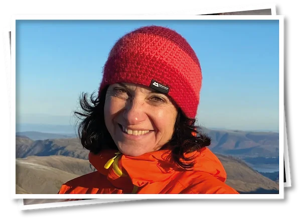 hristel, owner of North View B&B, on top of a Lake District fell wearing warm mountain gear, showcasing guided walks and outdoor experiences near Penrith